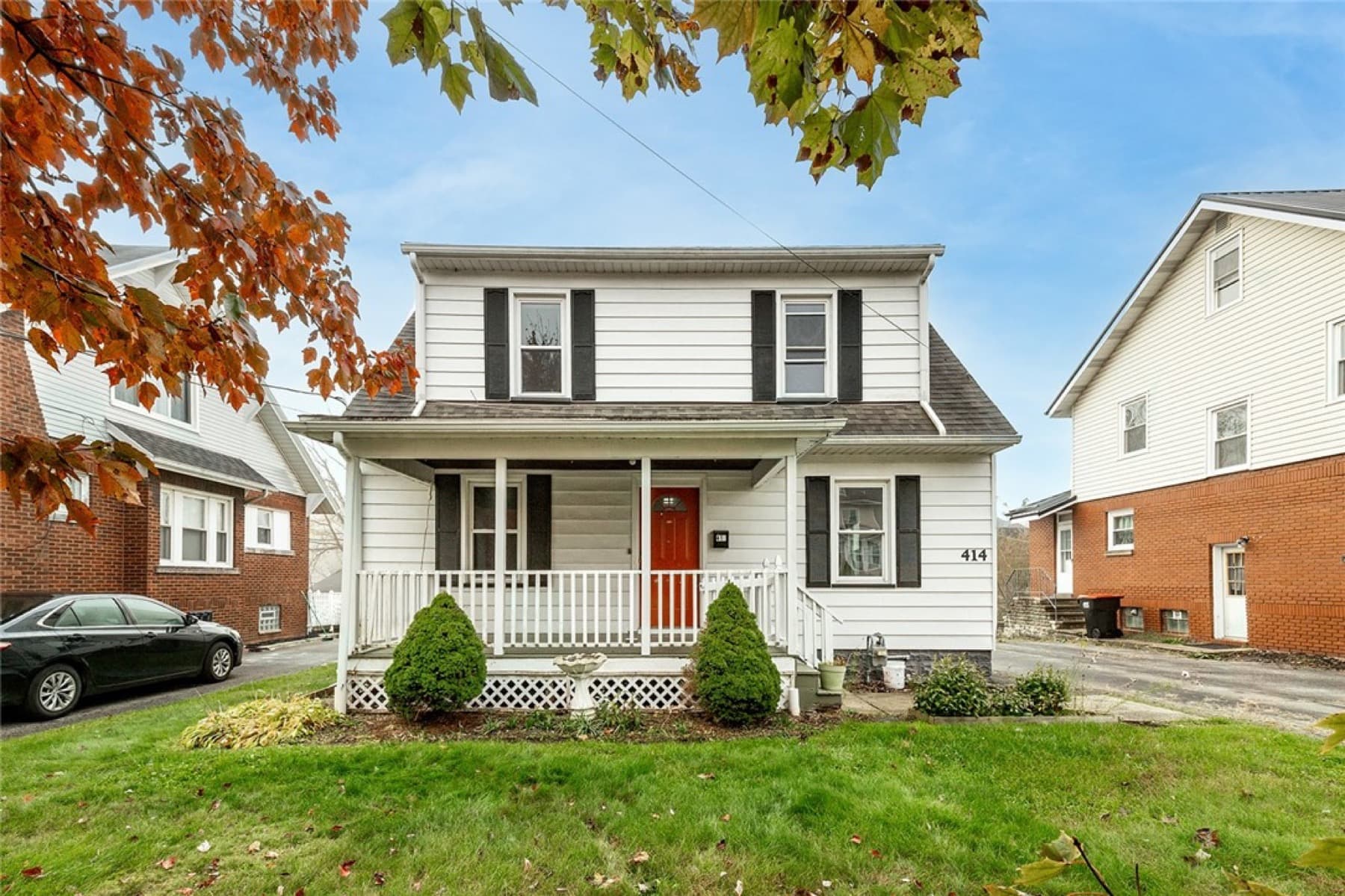 Front of 414 Norwood Avenue, a white Cape Cod with a covered porch and red door