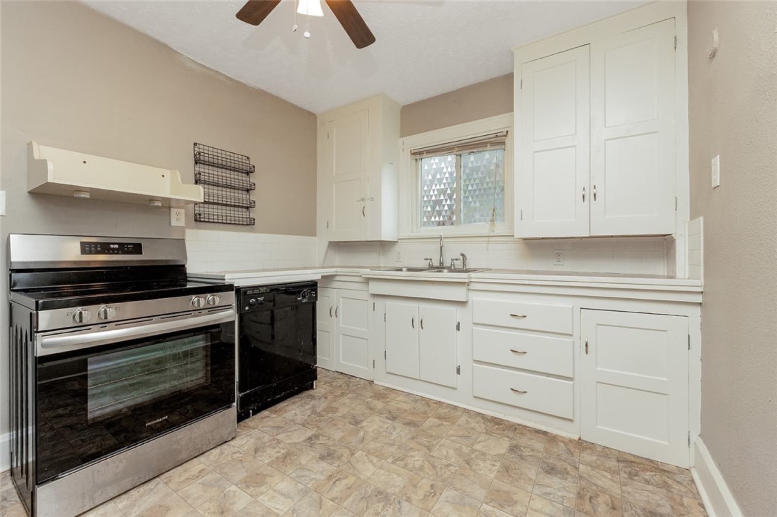 Kitchen with white cabinets, a tile backsplash, and a tile floor